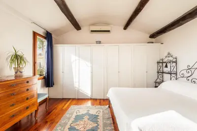 a bedroom with white cabinets and a bed and a dresser at Piazza Mattei Terrace Apartment | Romeloft in Rome