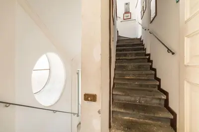a staircase in a house with a round window at Piazza Mattei Terrace Apartment | Romeloft in Rome
