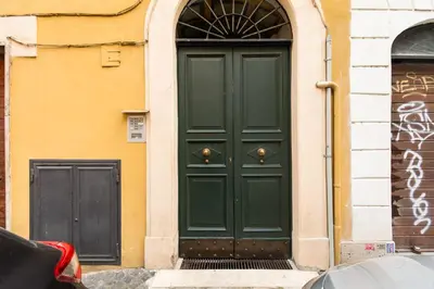 a green door on the side of a building at Piazza Mattei Terrace Apartment | Romeloft in Rome