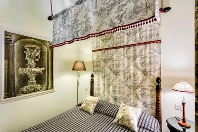 a bedroom with a bed and a curtain at Casa Heberart Guest House Capo le Case in Rome