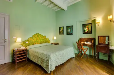 a bedroom with a bed and a table and a desk at Casa Heberart Guest House Capo le Case in Rome