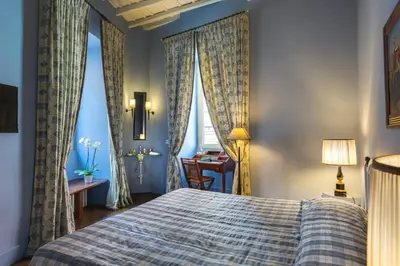 a bedroom with a bed and a desk and curtains at Casa Heberart Guest House Capo le Case in Rome