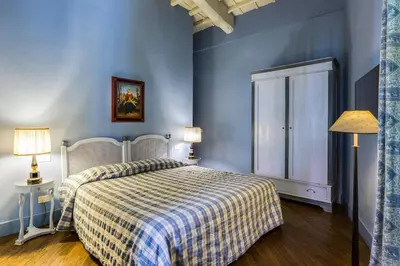 a bedroom with a bed with a plaid blanket at Casa Heberart Guest House Capo le Case in Rome