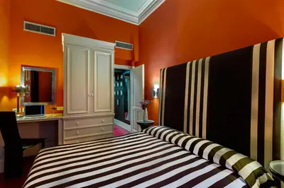 a bedroom with orange walls and a bed in a room at Casa Heberart Guest House Sistina in Rome