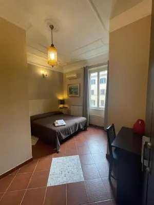 a bedroom with a bed and a table and a window at Santa Bibiana B&B in Rome