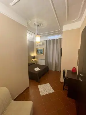 a room with a bed and a table and a couch at Santa Bibiana B&B in Rome