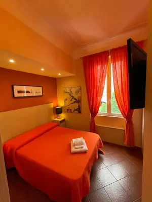 a bedroom with a red bed and a window at Santa Bibiana B&B in Rome