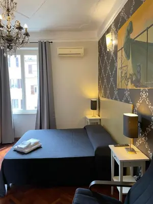 a bedroom with a bed and a couch and a table at Santa Bibiana B&B in Rome