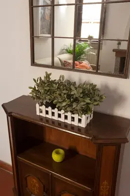 a table with a mirror and a potted plant on it at The Piccolo Apartment in Rome