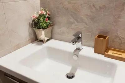 a bathroom sink with a vase of flowers on it at The Piccolo Apartment in Rome