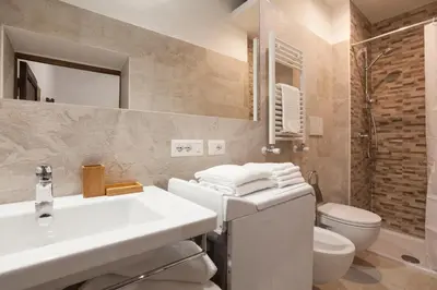 a white bathroom with a sink and a toilet at The Piccolo Apartment in Rome