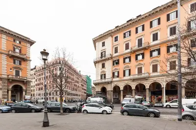 a city street with cars parked in front of buildings at Magic Door Rome in Rome