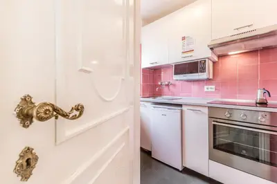 a kitchen with pink tiled walls and a white door at Il Palazzetto di Via della Frezza in Rome