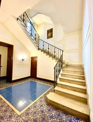 a house with a staircase and a blue tile floor at Il Palazzetto di Via della Frezza in Rome
