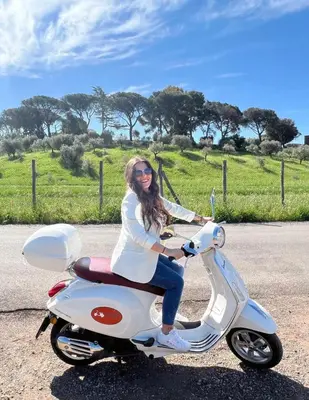 a woman sitting on a scooter on the road at Il Palazzetto di Via della Frezza in Rome