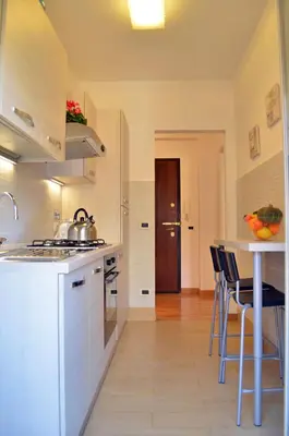 a kitchen with white cabinets and a table with chairs at Roma Caput Mundi in Rome