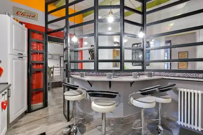 a bar with stools in a barbershop at Rome As You Feel - Design Apartment at Colosseum in Rome