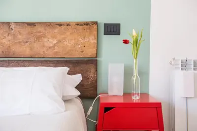 a red nightstand with a vase on top of a bed at Le Stanze Di Paola in Rome