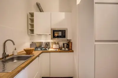 a small kitchen with white cabinets and a sink at Vaticano casa tua in Rome