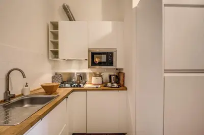 a kitchen with white cabinets and a sink at Vaticano casa tua in Rome