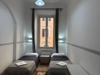 a row of beds in a room with a window at Zidan Guest House in Rome