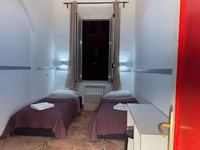 two beds in a small room with a window at Zidan Guest House in Rome