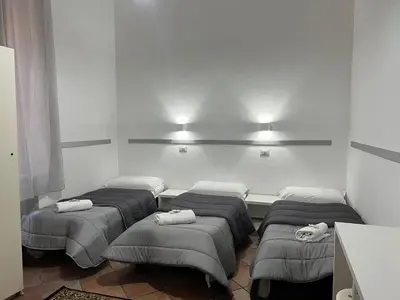 a room with four beds in a room with lights at Zidan Guest House in Rome