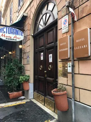 a large wooden door on a building with potted plants at Zidan Guest House in Rome