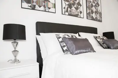 a bedroom with a white bed with black and white pillows at Argentina Exclusive Apartment in Rome