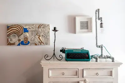 a desk with a typewriter and a painting on the wall at AndreaSuite - Piazza Navona in Rome