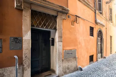an orange building with a black door on a street at AndreaSuite - Piazza Navona in Rome