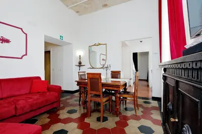 a living room with a table and a red couch at Dolce Casa Colosseo in Rome