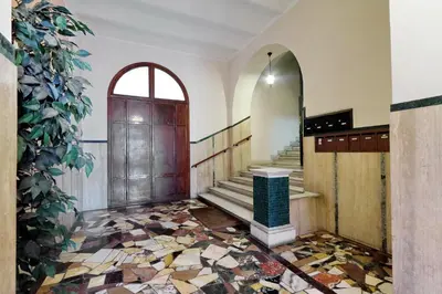 a lobby with a staircase with a mirror and a door at Dolce Casa Colosseo in Rome