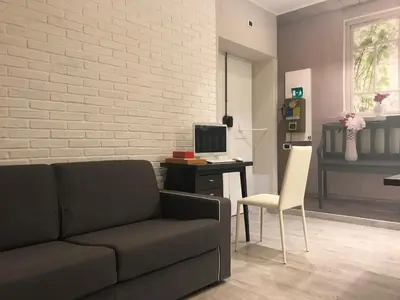 a living room with a couch and a desk with a computer at The Flower Market Apartment in Rome