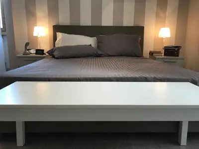 a white bed with two pillows on top of it at The Flower Market Apartment in Rome