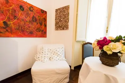 a room with a chair and a vase of flowers at A Casa Cibella in Rome