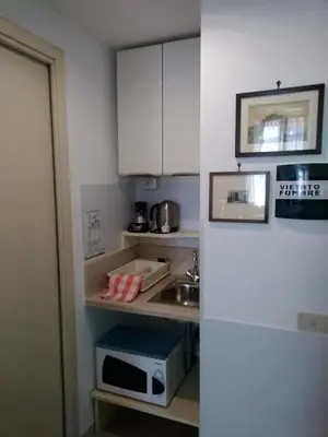 a small kitchen with a sink and a microwave at A Casa Cibella in Rome