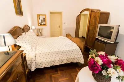 a bedroom with a bed and a tv and flowers at A Casa Cibella in Rome