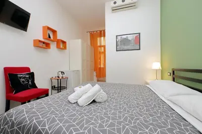 a bedroom with a bed and a red chair at Lucky Holiday Rooms in Rome