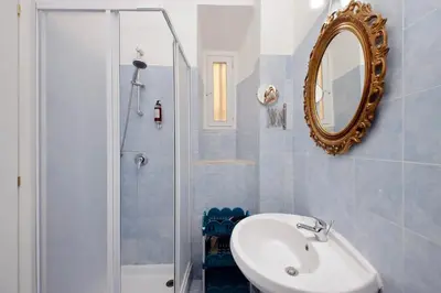 a bathroom with a sink and a mirror and a shower at Lucky Holiday Rooms in Rome