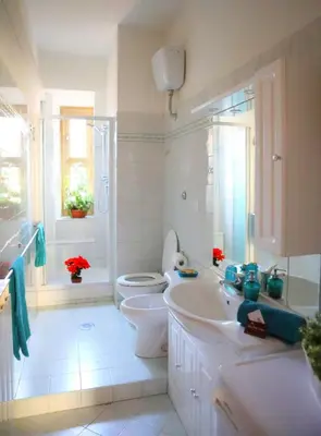 a white bathroom with a toilet and a sink at Linda Musei Vaticani in Rome
