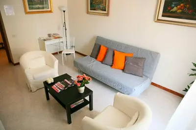 a living room with a blue couch and orange pillows at Linda Musei Vaticani in Rome