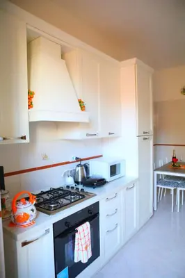 a kitchen with white cabinets and a stove top oven at Linda Musei Vaticani in Rome