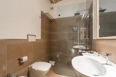 a bathroom with two sinks and a toilet and a mirror at TrinitaDeiMonti Guest House in Rome