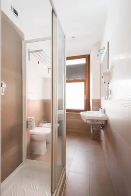 a bathroom with a shower and a toilet and a sink at TrinitaDeiMonti Guest House in Rome