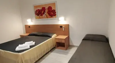 a bedroom with two beds and a painting on the wall at Friendship Place in Rome