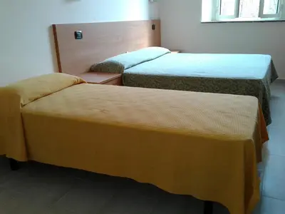 a room with three beds in a room at Friendship Place in Rome