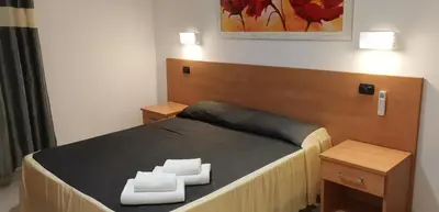 a bedroom with a bed with a wooden head board at Friendship Place in Rome