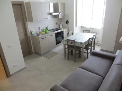 a kitchen and dining room with a table and a couch at San Pietro house in Rome