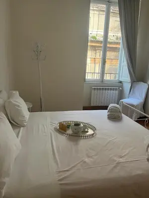 a white bed with a plate of food on it at ROMA - Loft Campo de' Fiori - Appartamento Campo de' Fiori - LE CUGINE in Rome